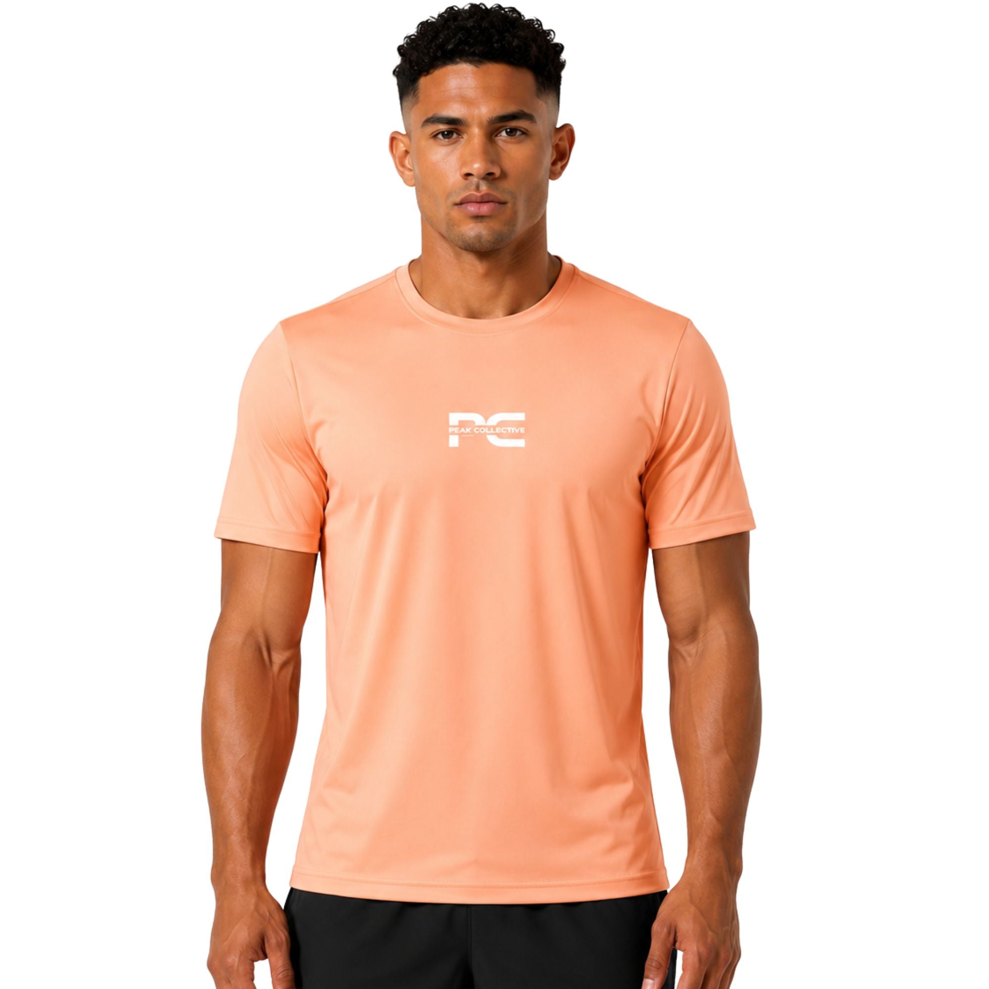 Male model wearing peach AeroTee Sapphire short-sleeve performance shirt with logo on white background – lightweight men’s running top for gym workouts, training, jogging, and activewear performance