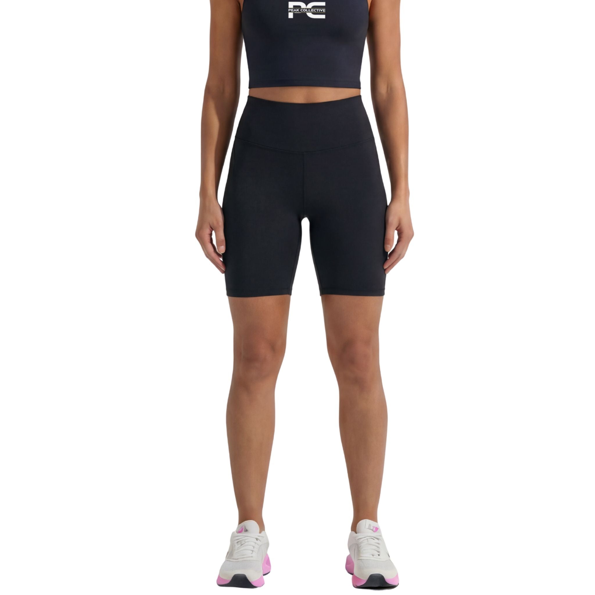Person wearing black AuraShorts athletic shorts and AuraCrop sports top with logo, front view on white background, ideal for gym workouts, running, and active lifestyle