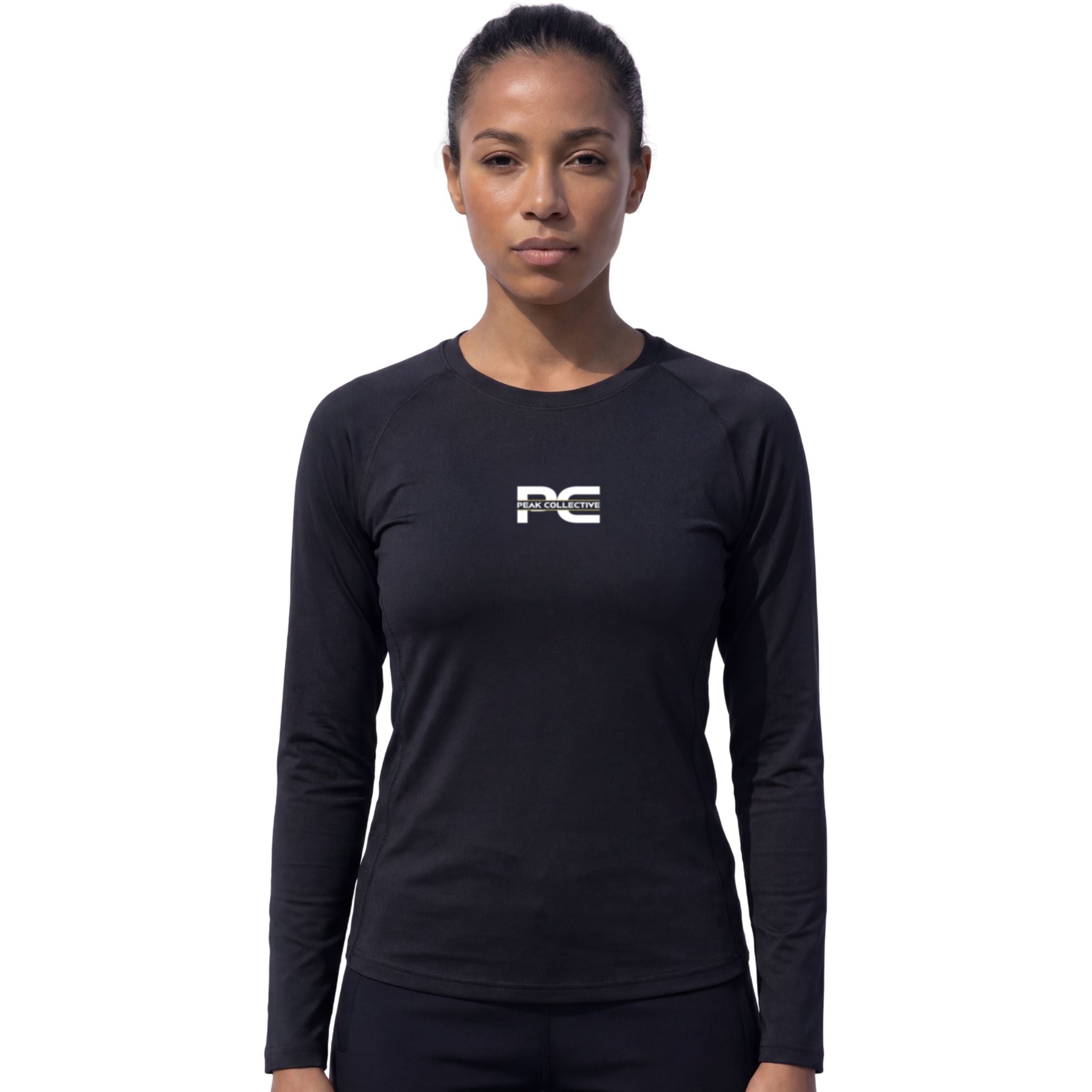 Female model wearing AuraSleeve black long-sleeve performance top with visible Peak Collective logo on white background – lightweight moisture-wicking women’s running shirt for training, running, jogging, gym workouts, and active performance wear