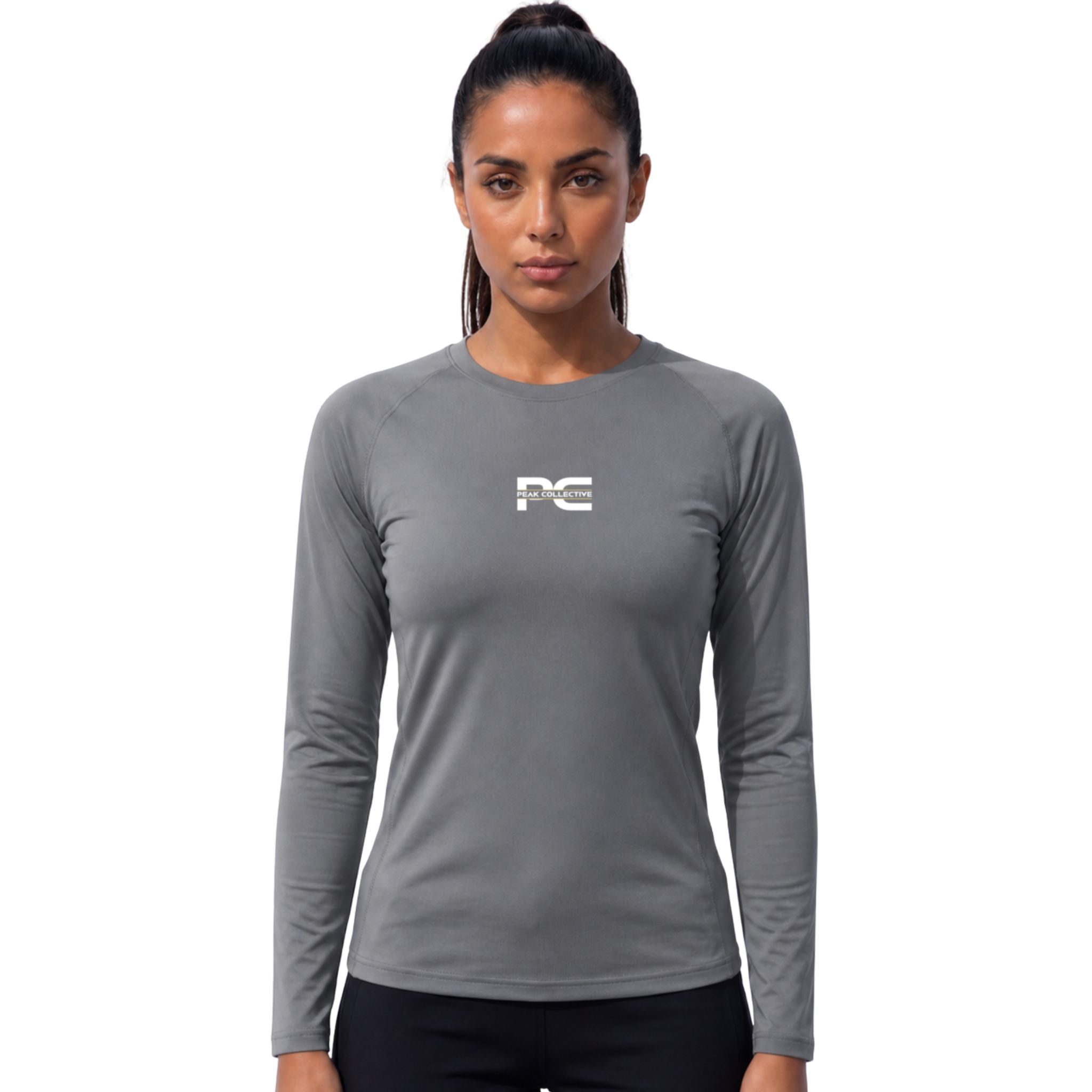 Female model wearing AuraSleeve grey long-sleeve performance top with visible Peak Collective logo on white background – lightweight moisture-wicking women’s running shirt for training, running, jogging, gym workouts, and active performance wear