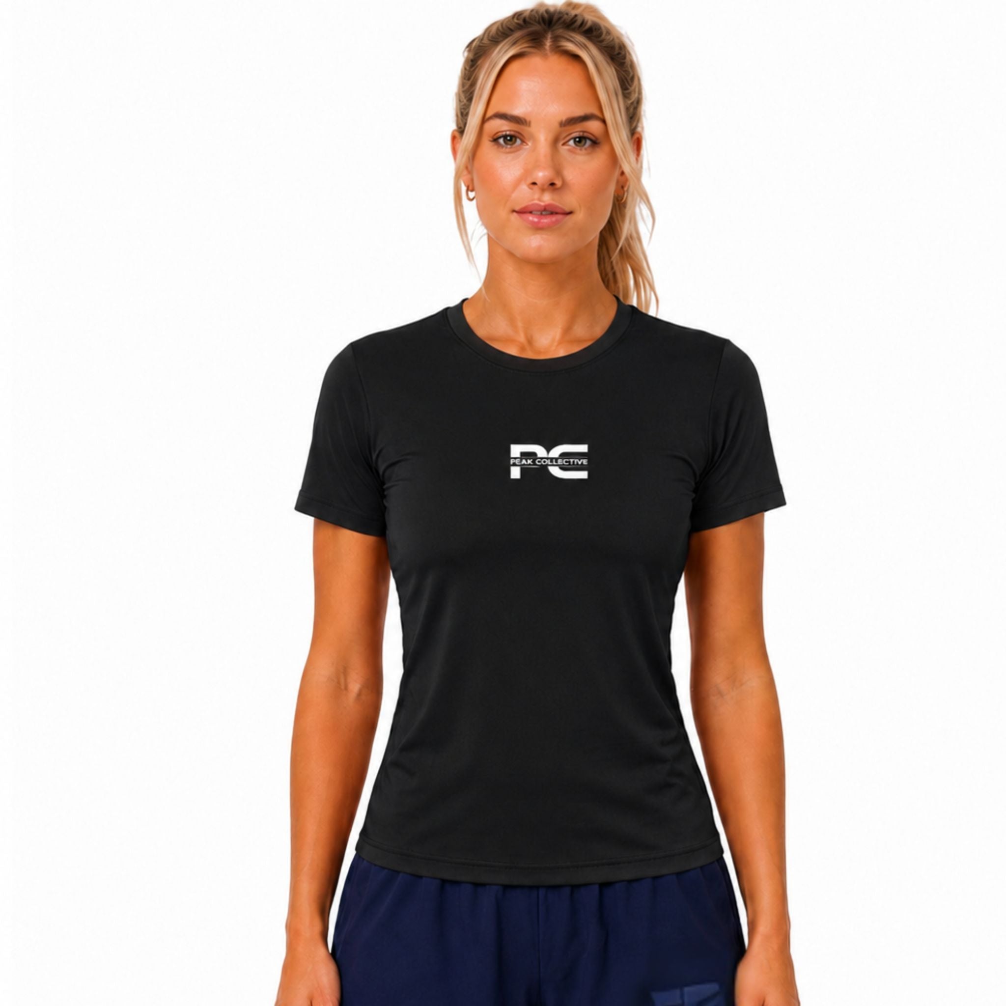 Woman wearing black AuraTee athletic performance shirt with logo on white background – lightweight women’s running top for gym workouts, training, jogging, and everyday activewear