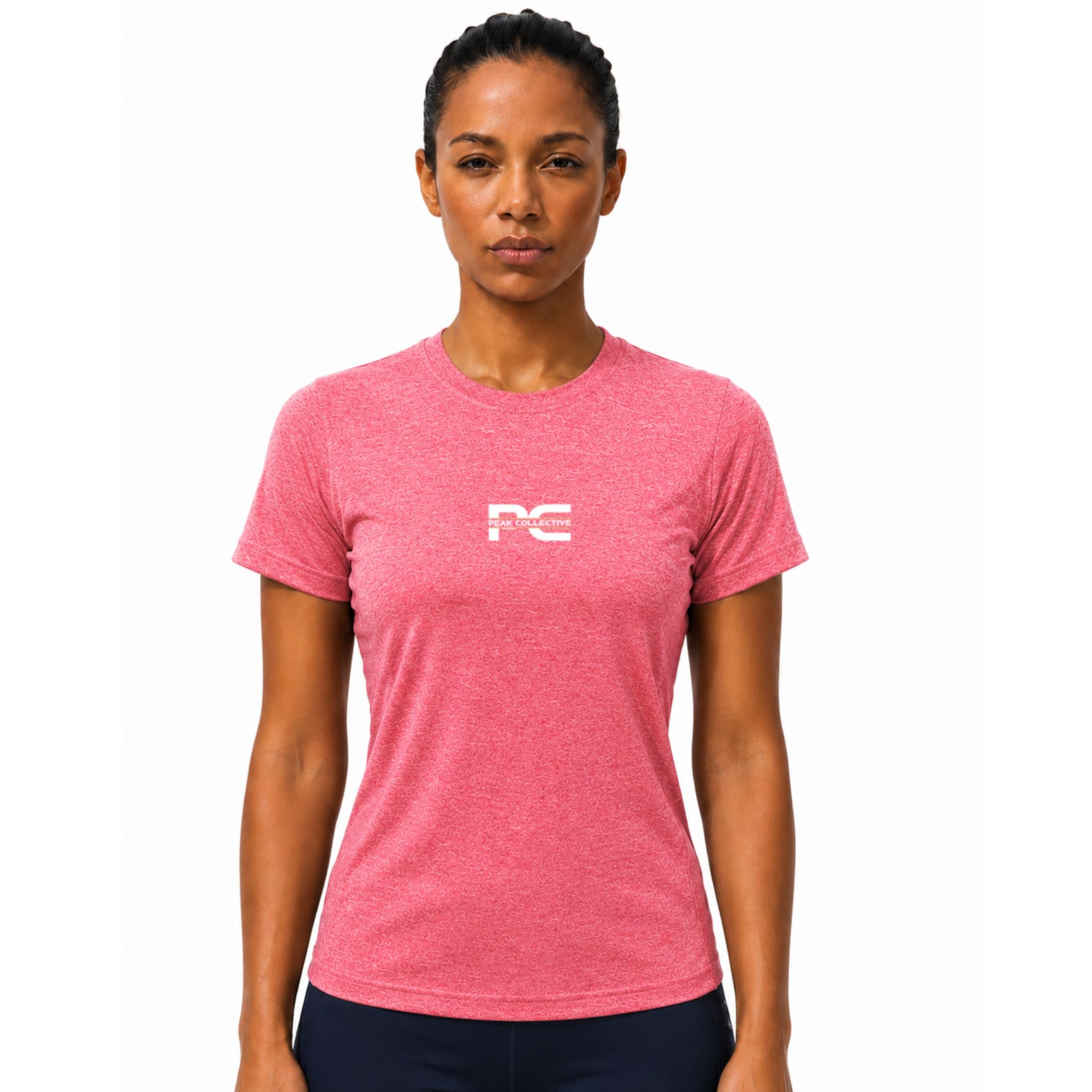 Woman wearing pink AuraTee athletic performance shirt with logo on white background – lightweight women’s running top for gym workouts, training, jogging, and everyday activewear