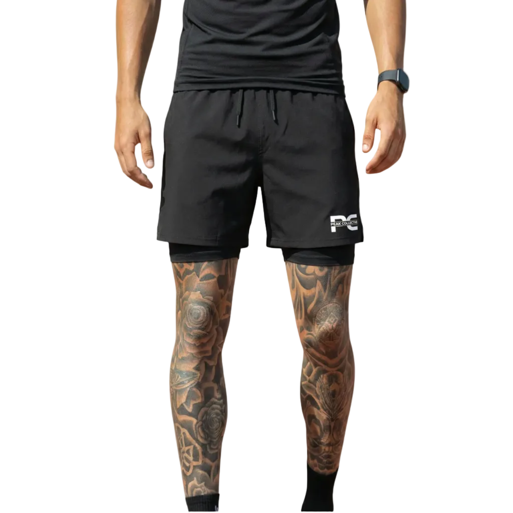 Person wearing CoreShorts men’s black double-layer sports shorts with four-way stretch, integrated undershorts, and zip pockets, ideal for running, gym workouts, and training, on a light grey background.