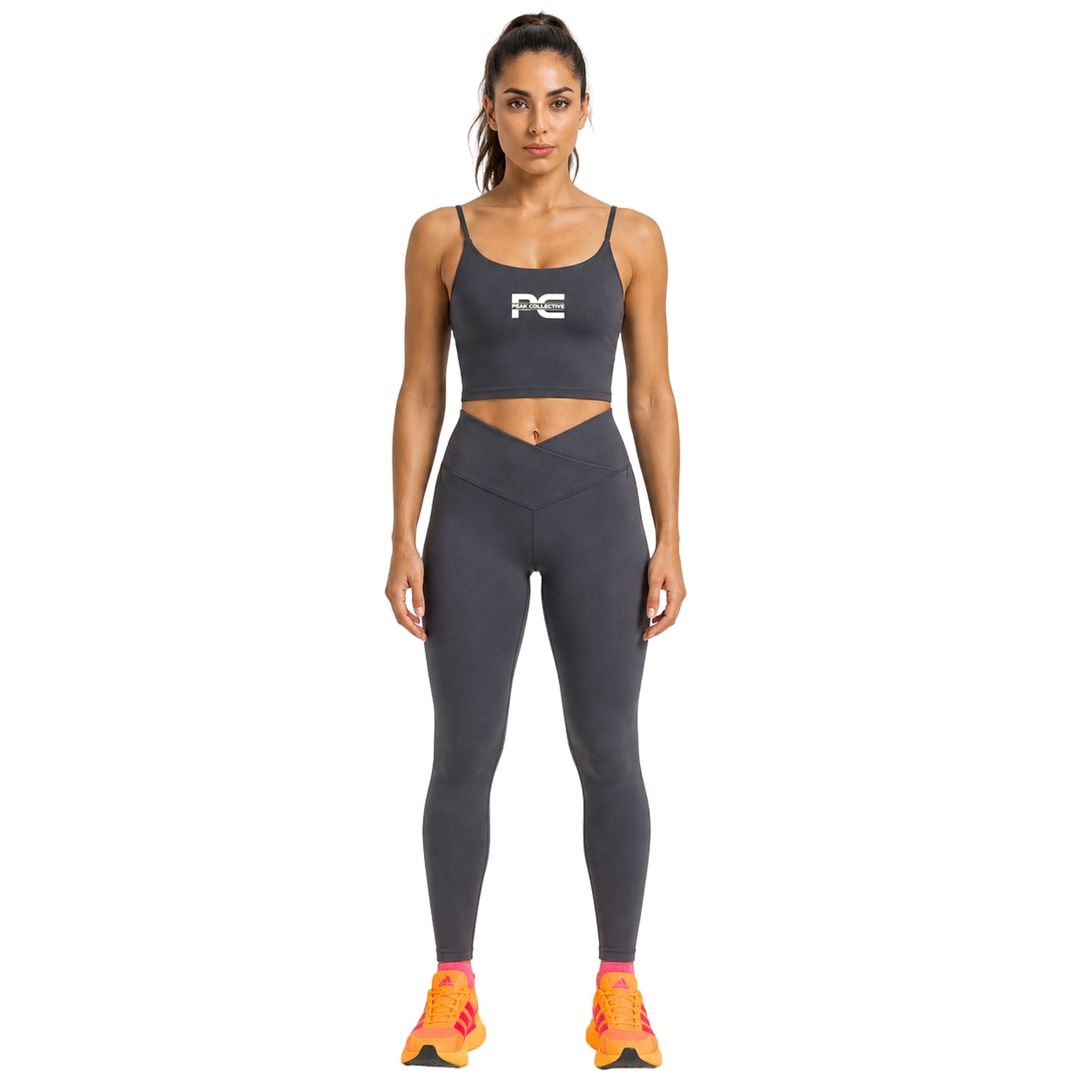 Woman wearing dark grey LumaCrop and grey LumaLeggings leggings activewear set with logo on white background – women’s matching fitness outfit for running, gym workouts, yoga, training sessions, and everyday activewear
