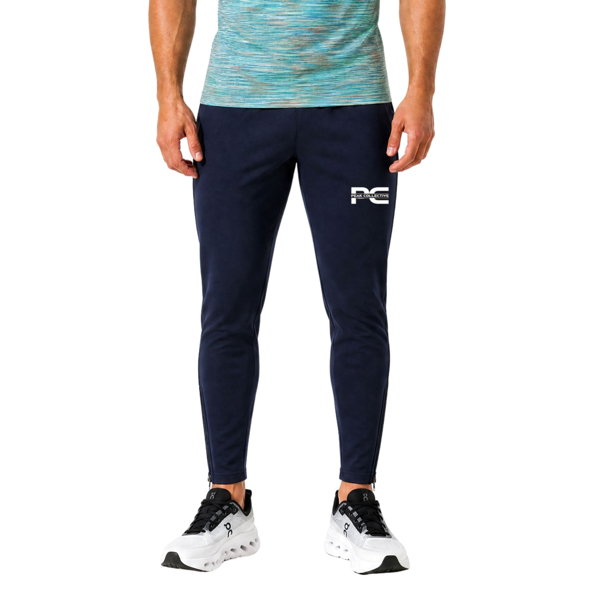 Man wearing navy AeroJoggers with logo on white background – slim-fit men’s performance joggers for running, gym workouts, training sessions, and everyday activewear