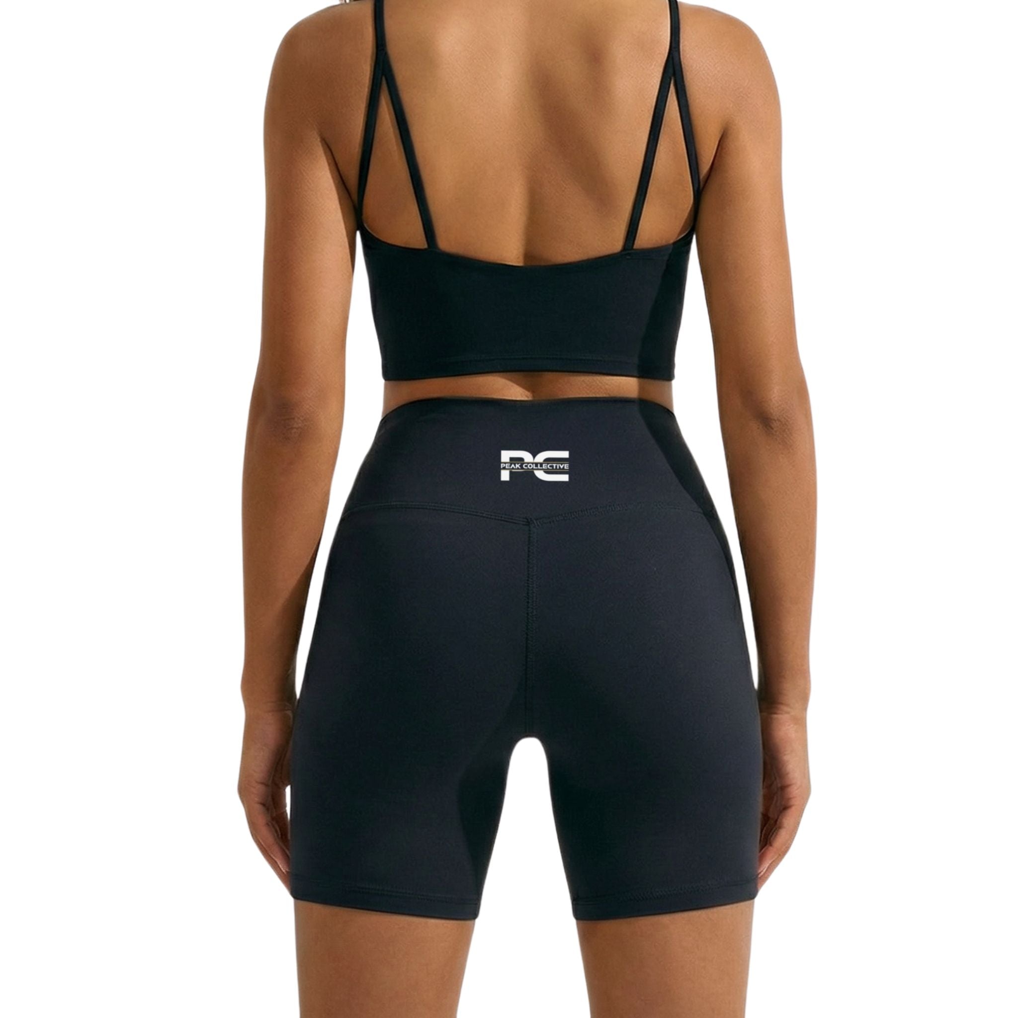 Person wearing black AuraCrop cropped sports bra top and black AuraShorts athletic shorts with logo, back view on white background, ideal for gym workouts, running, and active lifestyle
