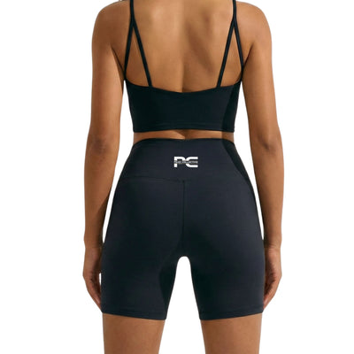 Person wearing black AuraCrop cropped sports bra top and black AuraShorts athletic shorts with logo, back view on white background, ideal for gym workouts, running, and active lifestyle