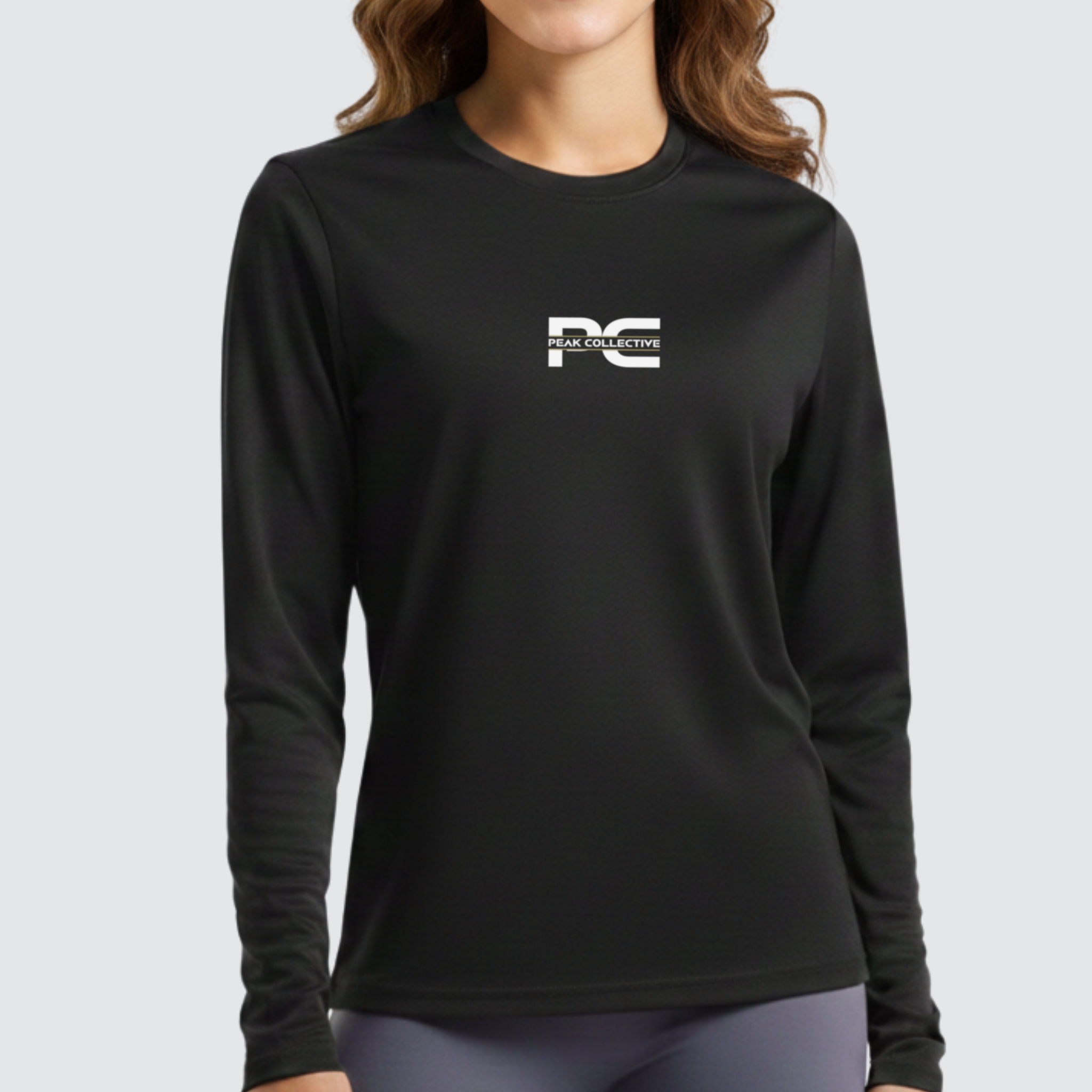 Model wearing AuraSleeve long sleeve performance top in black with a visible logo on a grey background, designed for running, training, and active workouts.