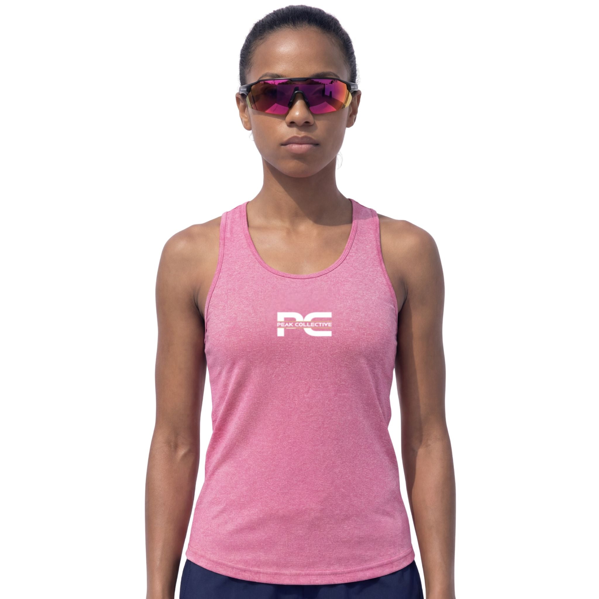 Woman wearing pink AuraVest tank top with logo and CoreLens rose-tint sunglasses on white background – lightweight women’s performance vest for running, gym workouts, training sessions, and everyday activewear