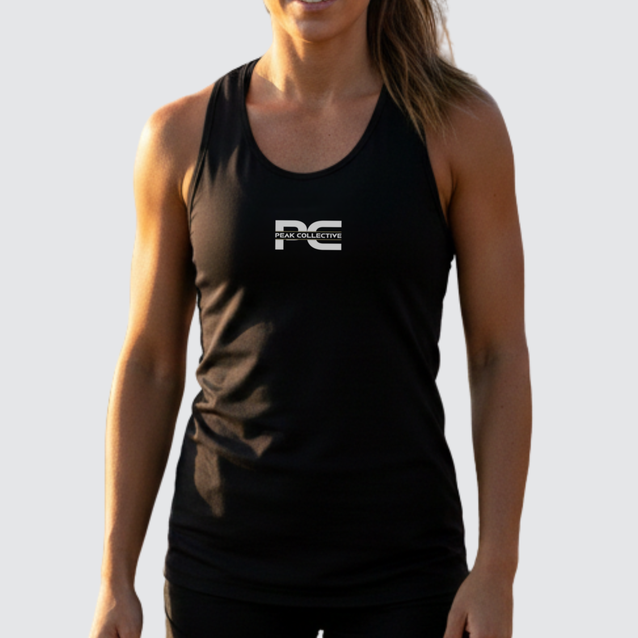 Woman wearing AuraVest women’s performance vest in black with a visible logo on a light grey background, designed for running, training, and active wear.
