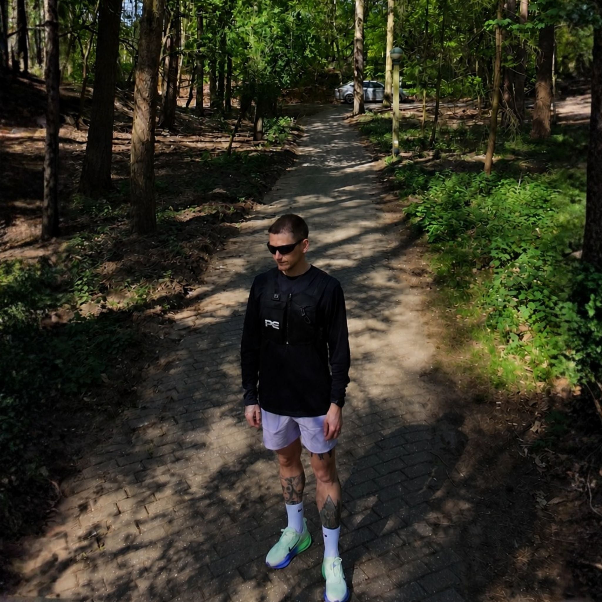 Male runner wearing Peak Collective CoreLens 3 in 1 running sunglasses with Smoke Lens on. The Model is also wearing a MagnaVest Performance running vest