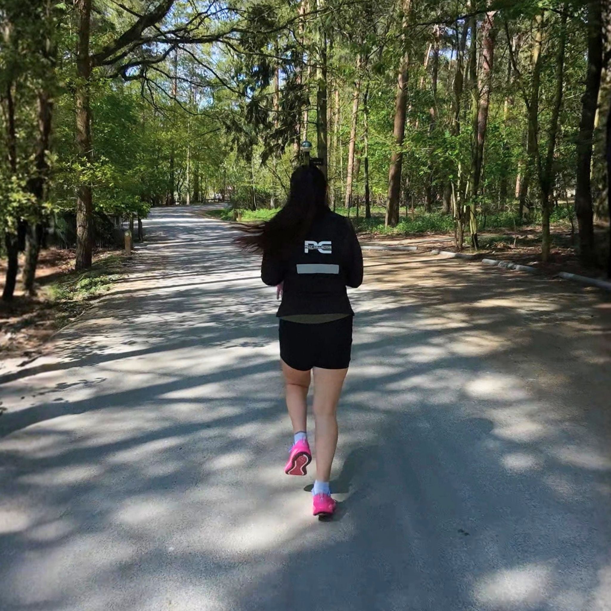 Female runner wearing MagnaVest running hydration vest mid stride running away from the camera