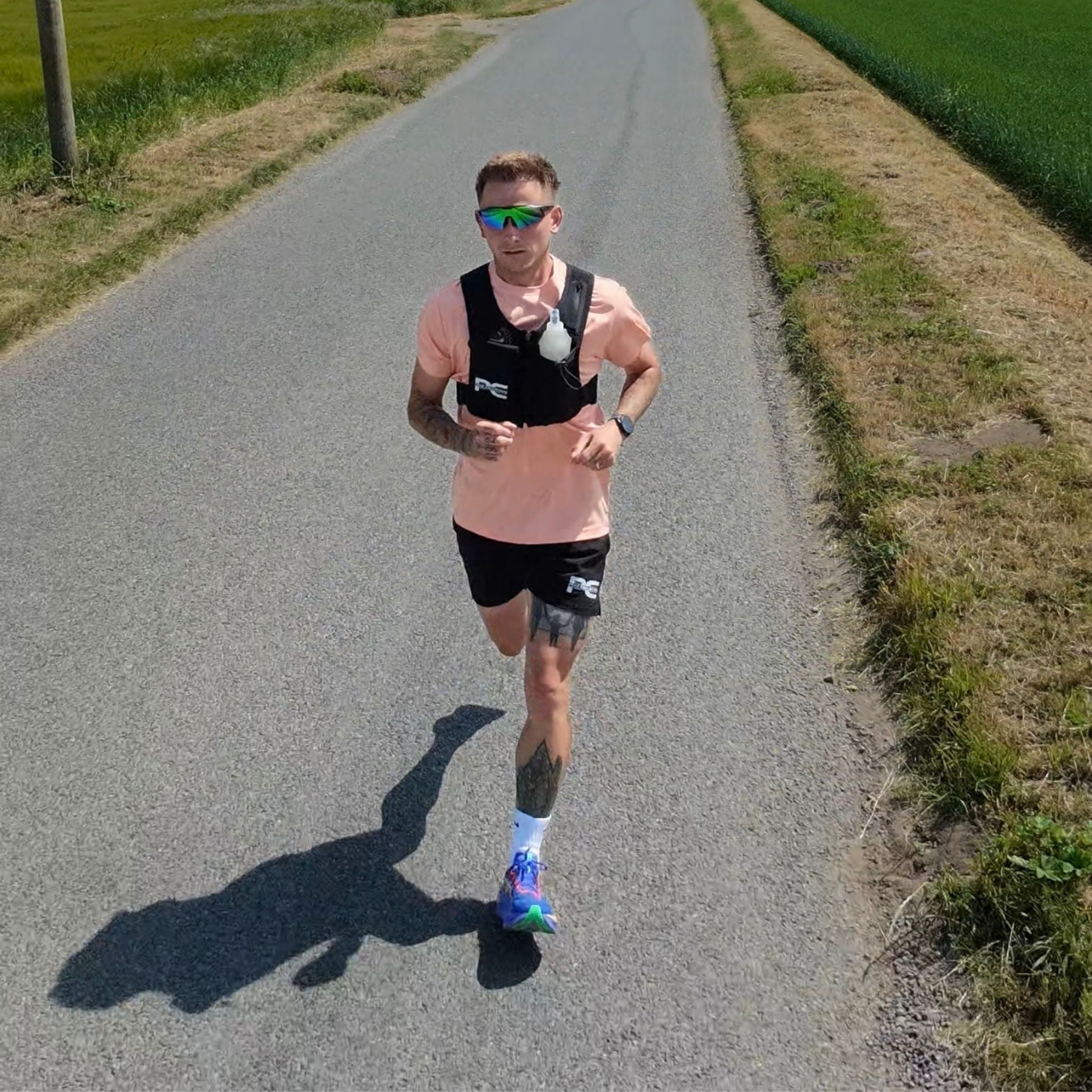 Male running towards the camera wearing MagnaVest, perfect for running with a magnetic phone closure pocket. Male is also wearing AeroTee Performance top, StrideShorts performance running shorts and CoreLens 3 in 1 running glasses