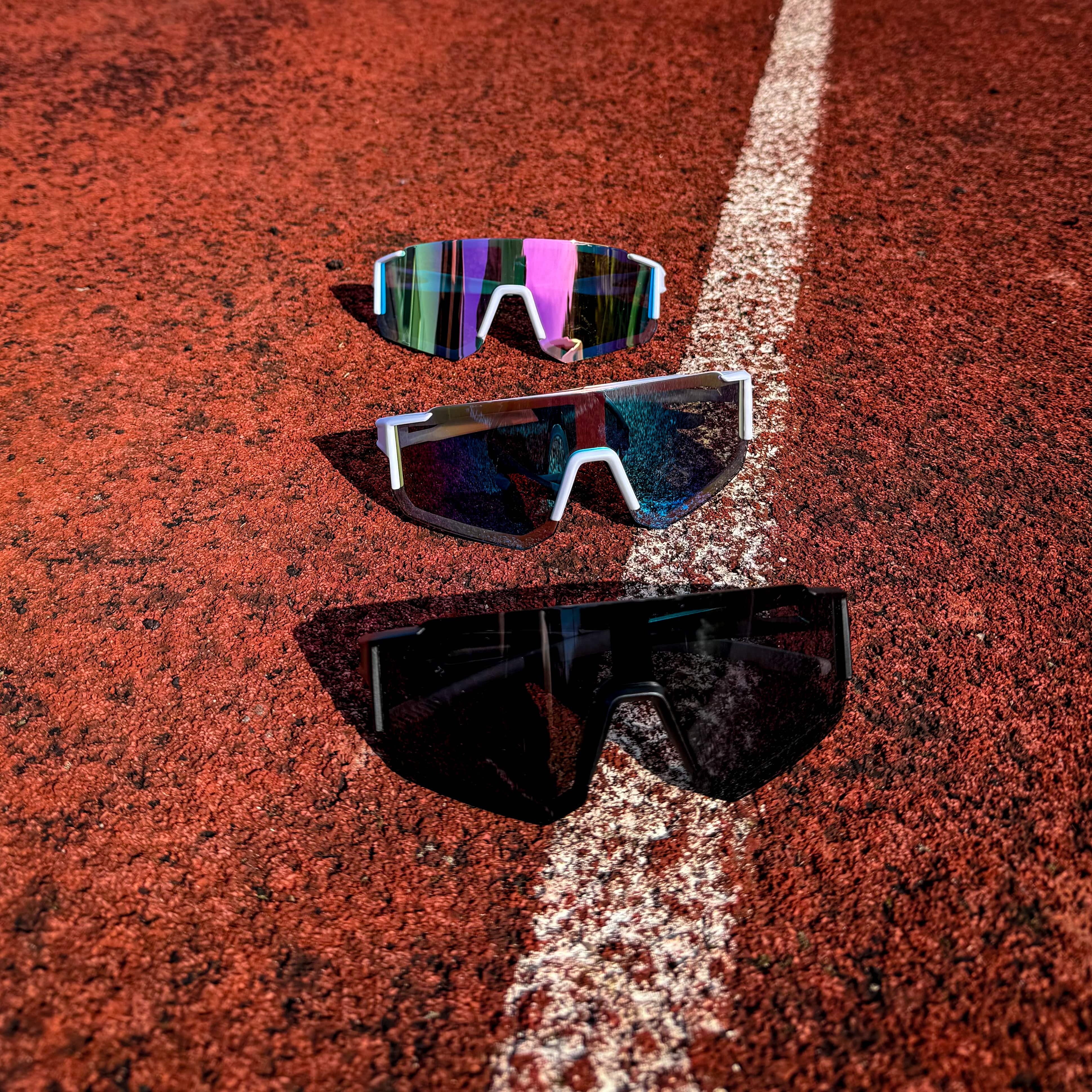 Front view of three StormLens performance sunglasses on a red track, designed for running, outdoor fitness, and high-intensity athletic activities.